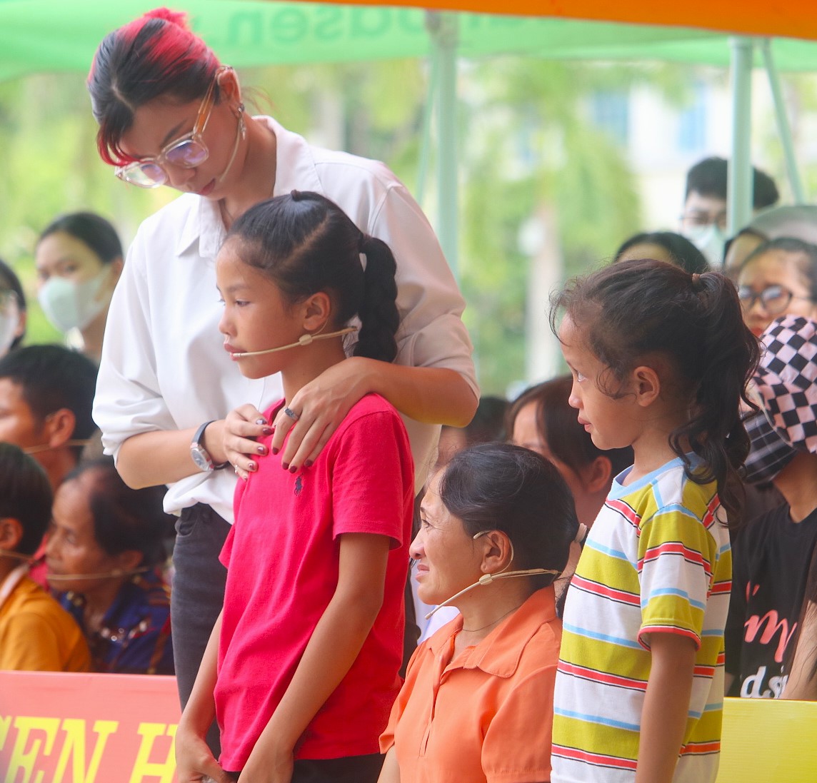 Diễn viên Đồng Ánh Quỳnh ôm các em nhỏ trên sân khấu, chia sẻ sự đồng cảm sâu sắc.