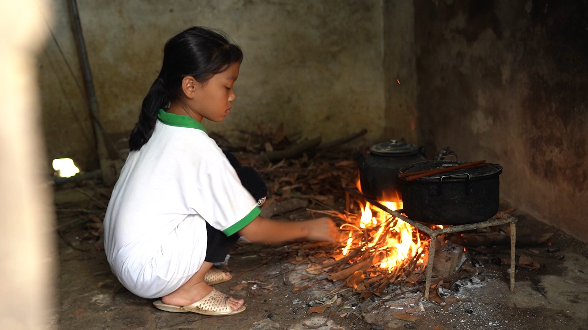Thân hình nhỏ bé của Chúc Ly trong gian bếp, lặng lẽ cố gắng phụ mẹ từng việc nhỏ.