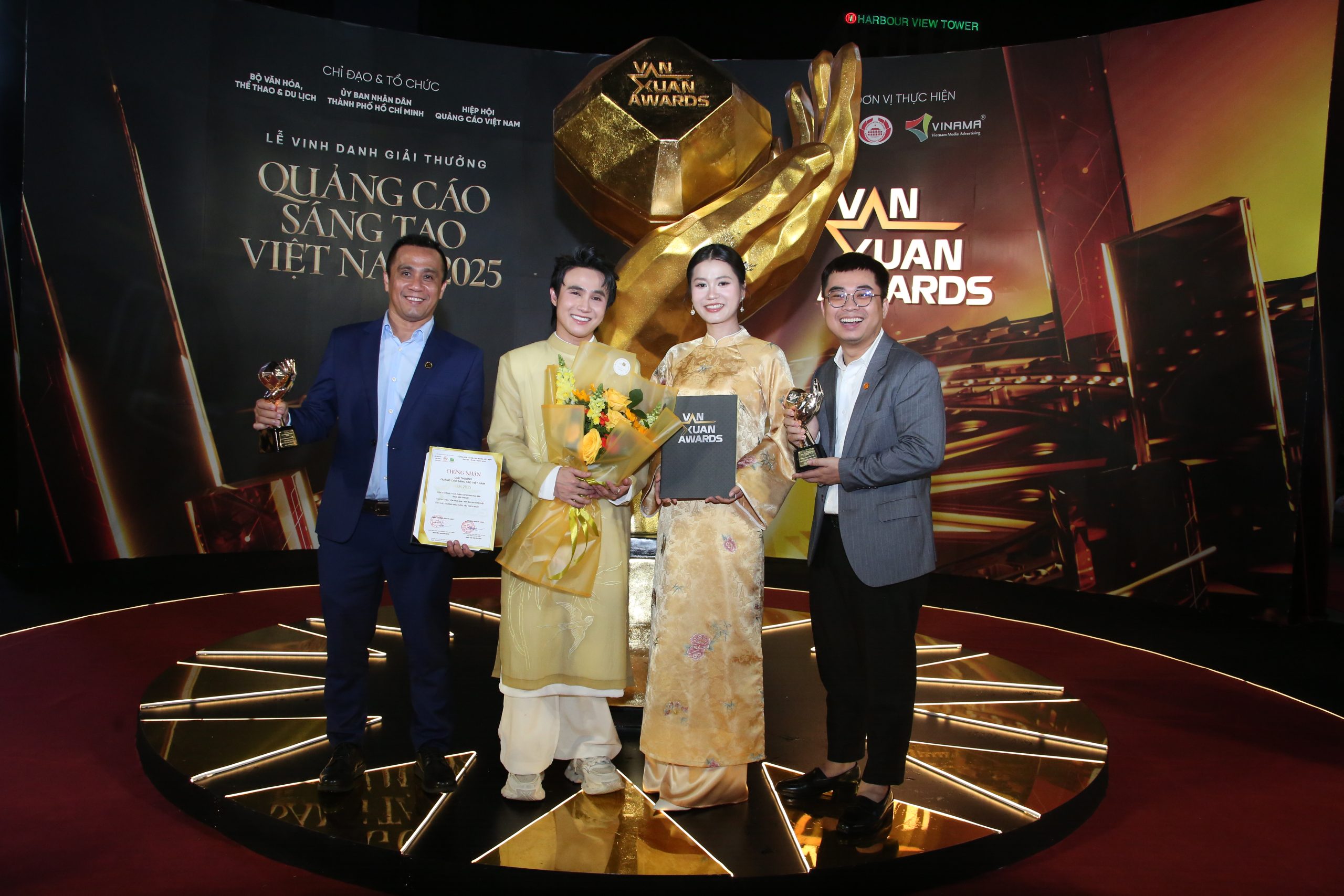 Ông Trần Đình Tài – Phó Tổng Giám đốc Tập đoàn Hoa Sen, ông Trần Đình Phương – Phó Tổng Giám đốc Công ty Truyền thông Bee cùng hai MC Mái ấm gia đình Việt Lâm Vỹ Dạ, Huỳnh Lập tại lễ trao giải Vạn Xuân Awards 2025.