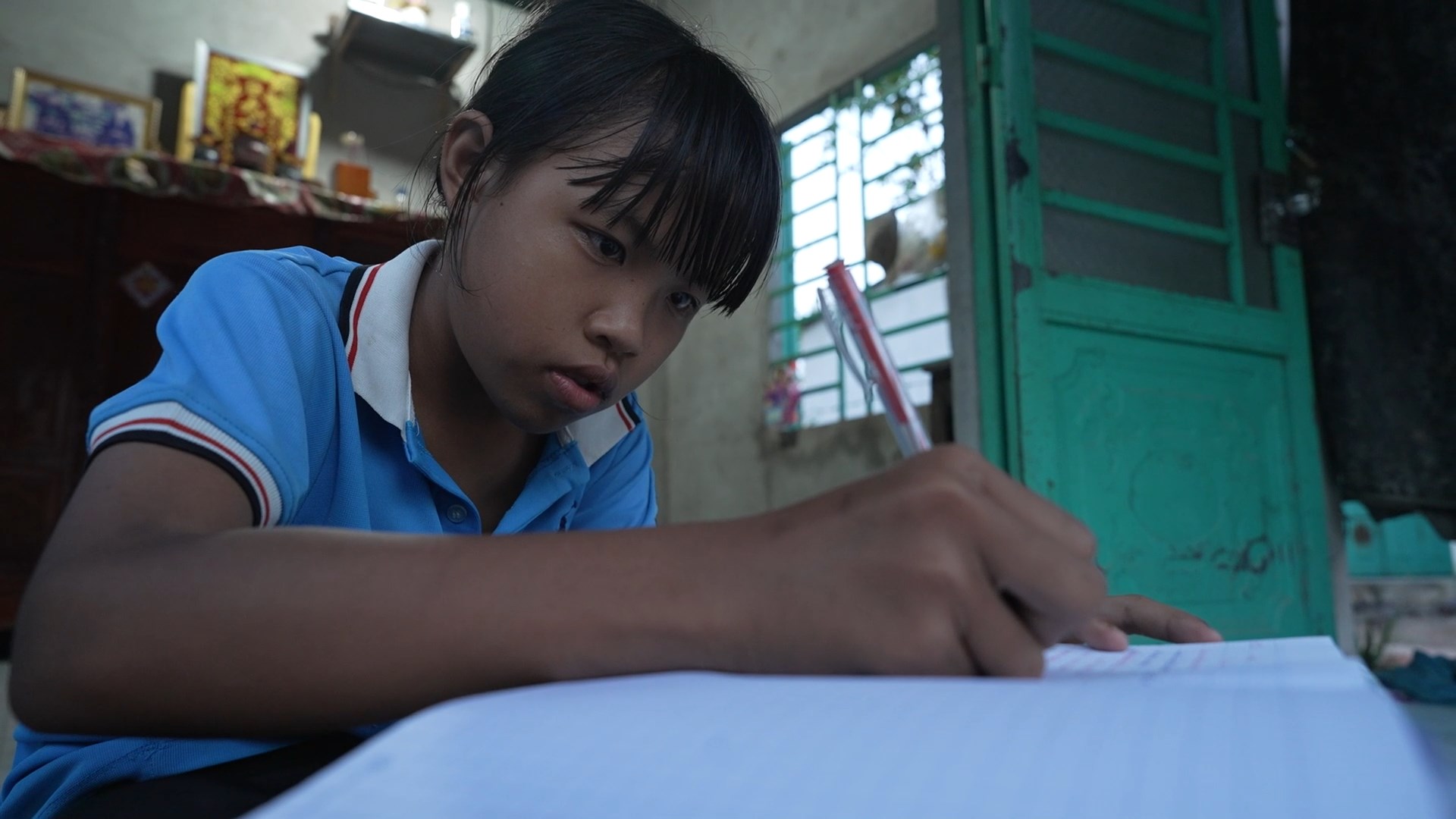 Em Hải Kim chăm chú học bài, luôn nỗ lực học tập dù gia đình nhiều khó khăn.