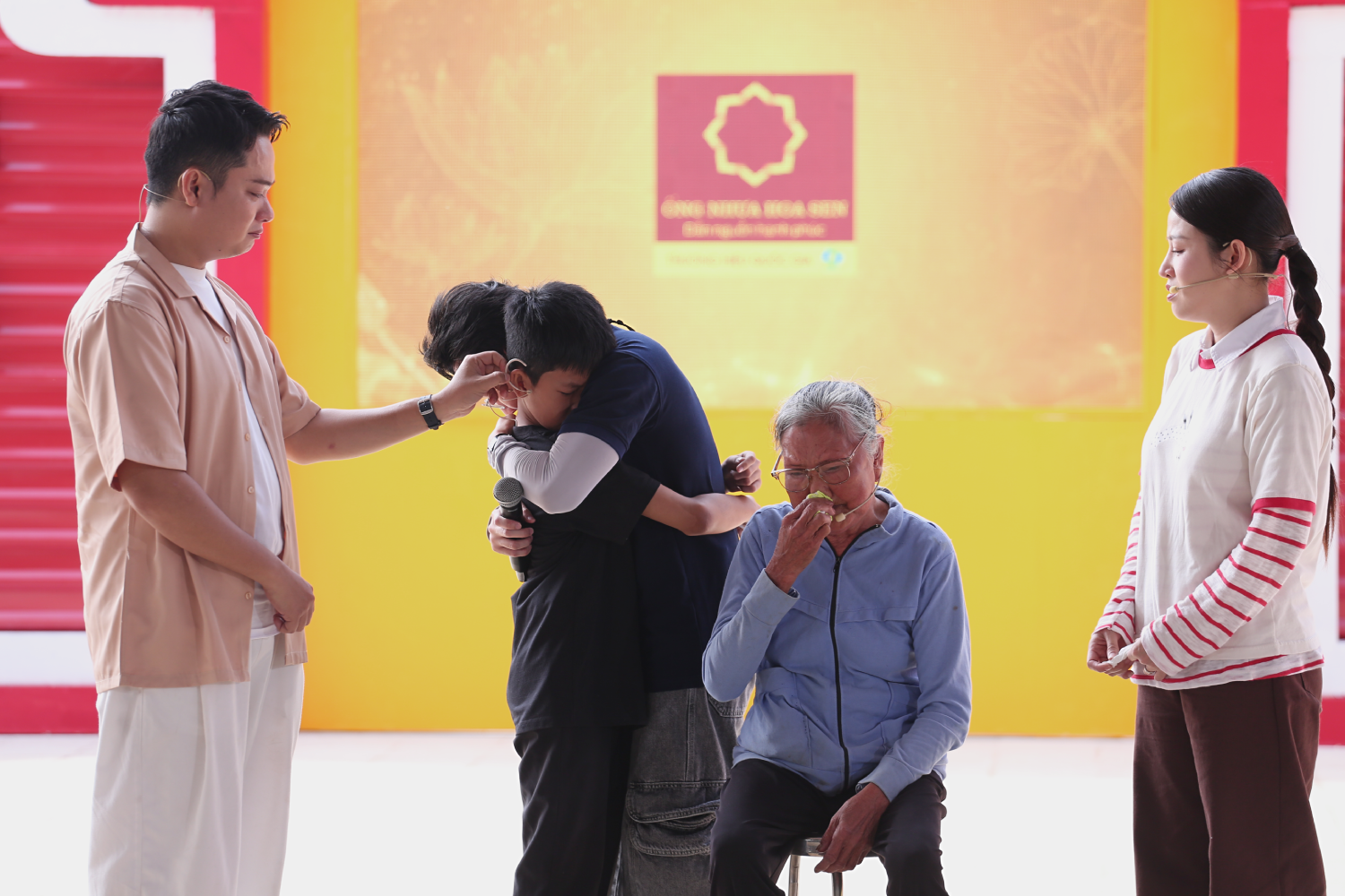 Huỳnh Lập ôm chặt cậu bé mồ côi cha, động viên em vượt qua những mất mát và tiếp tục đến trường.