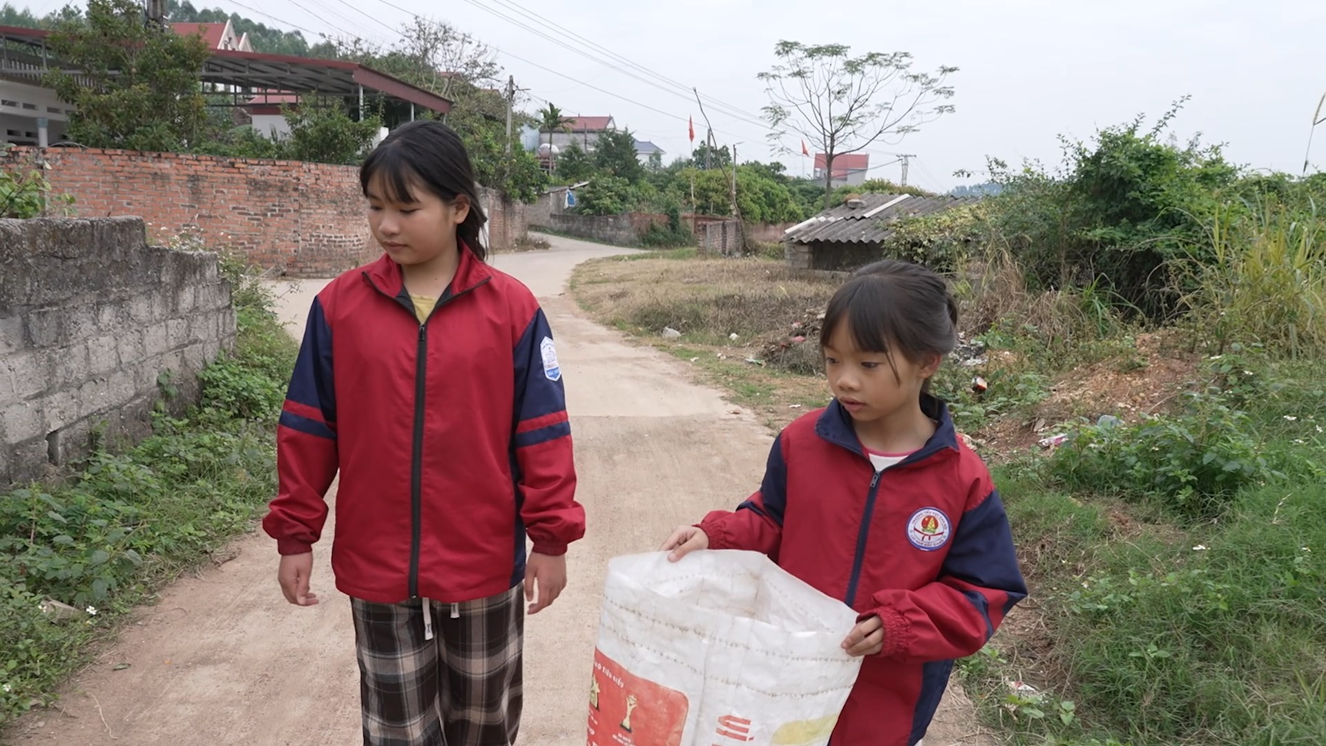 Hai chị em tranh thủ nhặt ve chai trên đường về để giúp đỡ bà.